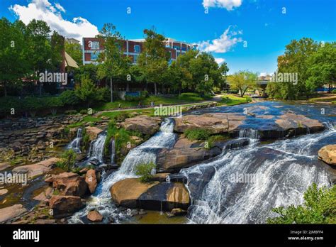 Scenic Waterfall Against Trees And Buildings Falls Park On The Reedy