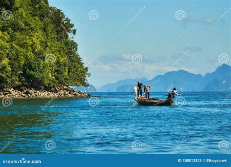 Wooden Boat Floating On Calm Water In Front Of Cliff Stock Image