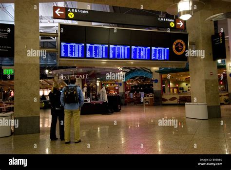 Airport Travelers Check Departures And Arrival Screens At Airport