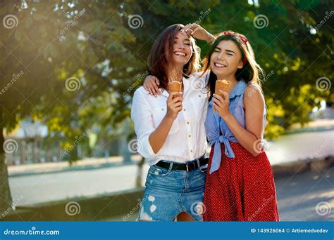 Dos Amigos Femeninos Jovenes Que Se Divierten Y Que Comen El Helado