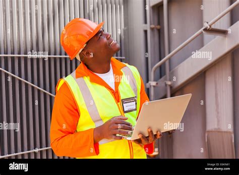 African Electrical Engineer Using Laptop In Substation Stock Photo Alamy