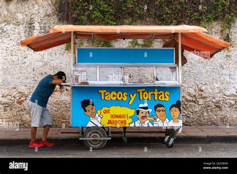 Street Vendor With His Head Down Resting On A Taco Cart In The Yucatan