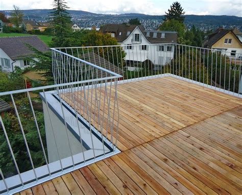 A Wooden Deck With Metal Railings And Houses In The Background