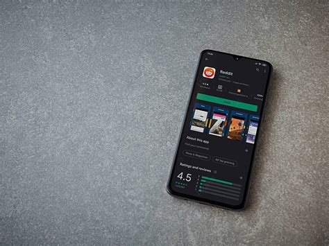 عرض هاتف ذكي أسود يعرض تطبيق Reddit على صفحة متجر Play صورة الخلفية