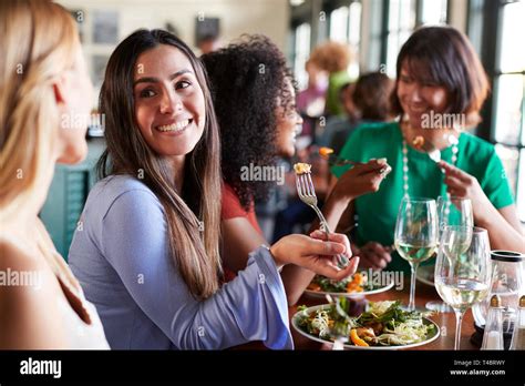 Group Of Female Friends Enjoying Meal In Restaurant Together Stock