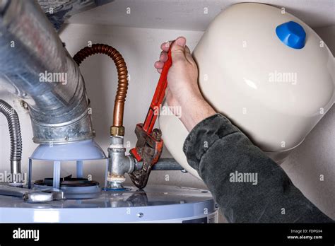 Man Works On A Hot Water Heater With A Pipe Wrench Stock Photo Alamy
