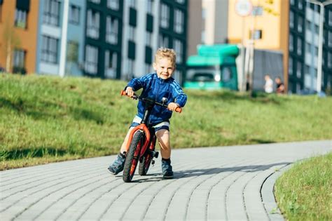 Niño andando en bicicleta en un parque de la ciudad Foto Premium