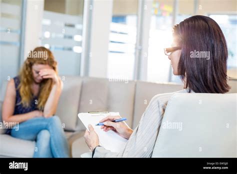 Psychologist Talking With Her Depressed Patient And Taking Notes Stock