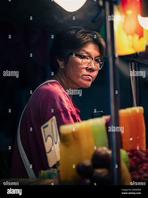 Woman Selling Freshly Squeezed Juice At A Night Market In Southeast