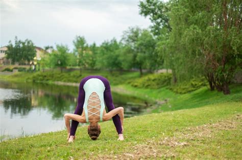 Premium Photo Slender Caucasian Brunette Girl Doing Yoga In Summer On A Green Lawn By The River