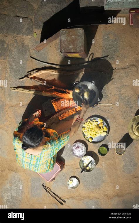 Rural Woman Cooking Food At Night In The Courtyard Of Her House For