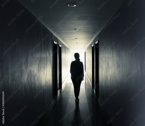 Women are walking alone in the dark.Light at the end of the tunnel concept Stock Photo | Adobe Stock