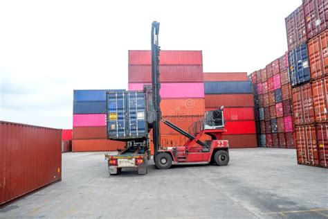 Container Handlers Put Containers Into Work Trucks In The Harbor Stock