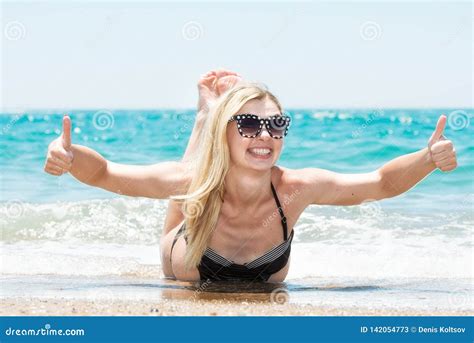 Bella Giovane Donna In Bikini Che Si Trova E Che Espone Al Sole Sulla Spiaggia Immagine Stock
