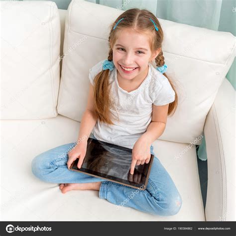 Joyeuse Petite Fille Avec Tablette Sur Ses Jambes En Regardant La