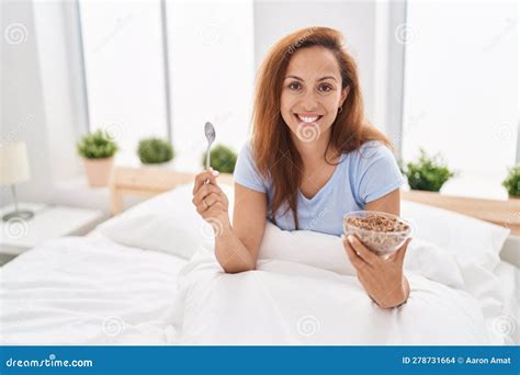 Brunette Woman Eating Breakfast In The Bed Smiling With A Happy And Cool Smile On Face Stock