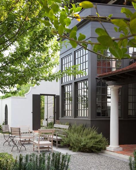 An Outdoor Patio With Chairs Tables And Trees In Front Of A Large