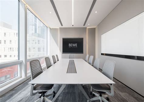 An Empty Conference Room With White Tables And Chairs