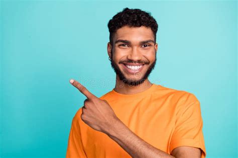 Photo Of Positive Cute Man Dressed Orange T Shirt Smiling Pointing