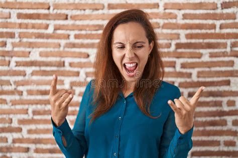 Brunette Woman Standing Over Bricks Wall Shouting With Crazy Expression