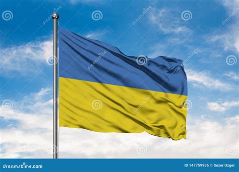 Flag Of Ukraine Waving In The Wind Against White Cloudy Blue Sky