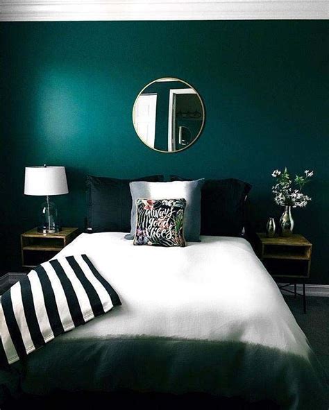 A Bedroom With Dark Green Walls And White Bedding Black And White