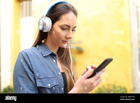 Woman Walks Listening To Music Selecting Songs In A Colorful Street