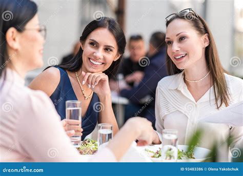 Cheerful Women Speaking With Colleague At Desk Stock Photo Image Of