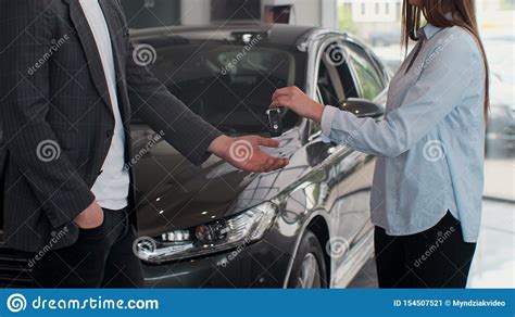 La Mano De Famale Da Llaves De Un Coche A La Mano Masculina En El