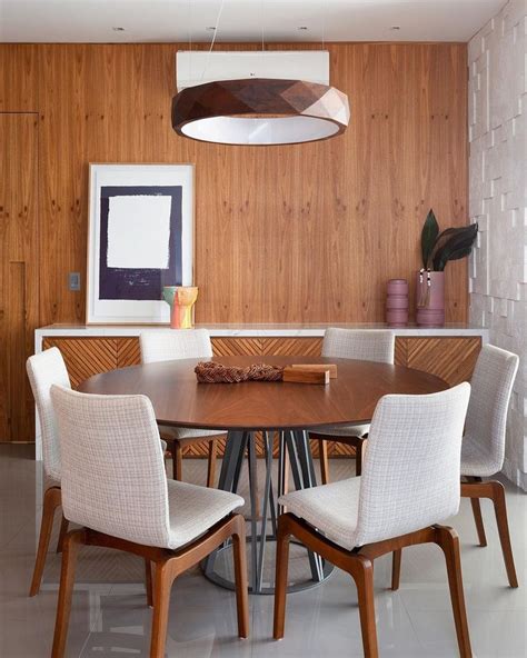 A Dining Room Table And Chairs With Wooden Paneling On The Wall In