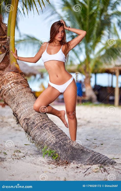 Beautiful Girl In White Bikini Posing At The Tropical Beach Stock Photo