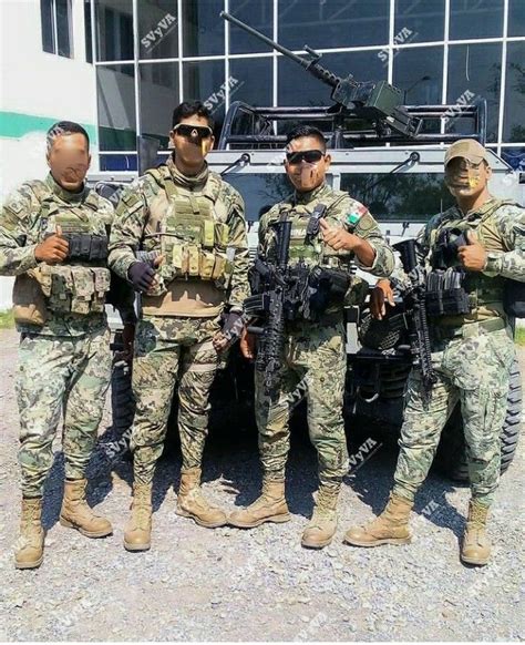 Four Soldiers Are Posing For A Photo In Front Of An Armored Vehicle With Their Arms Crossed