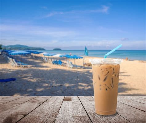 Ice Milk Coffee With Blurred Beach Sand And Blue Sea And Blue Sky Stock