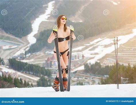 Smiling Naked Woman Is Standing On The Top Of The Slope With Skis Stock