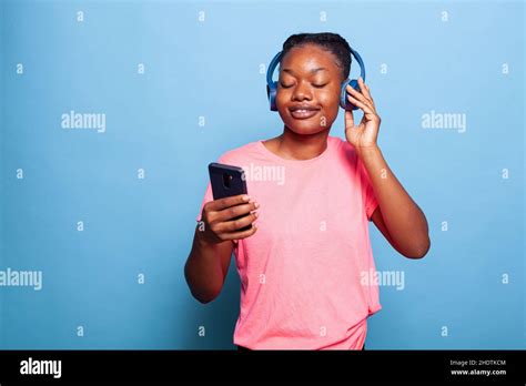 Portrait Of Smiling African American Young Woman Wearing Headphones