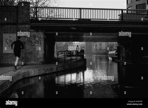 Black And White Image Of Commuters In The Early Morning Light On The