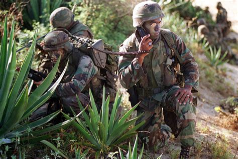 A US Marine Corps Platoon Leader And His Radioman Take Cover Along The