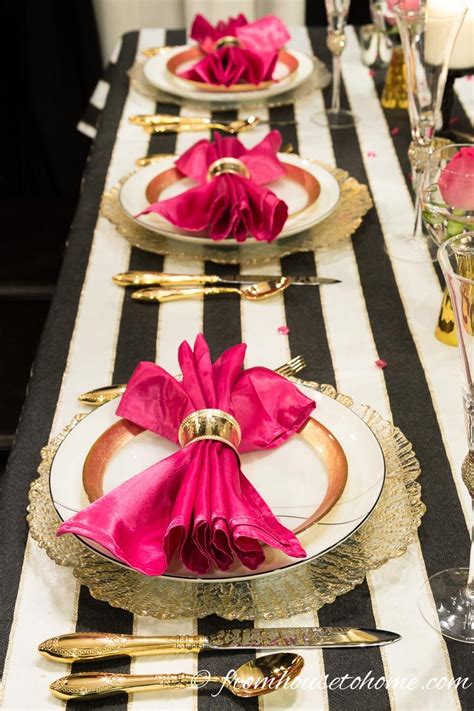 The Table Is Set With Black And White Striped Linens Gold Place