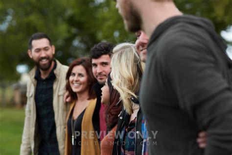 A United Group Of People Standing With Arms Around Each Other Stock