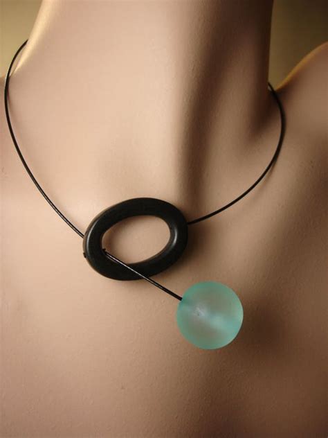 A Necklace With An Oval Pendant On A Mannequin