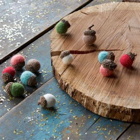 Small Balls Of Wool Are Placed On A Wooden Board Next To Some Pine