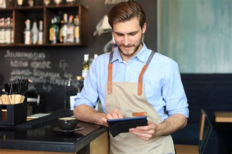 Premium Photo Young Male Owner Using Digital Tablet While Standing In