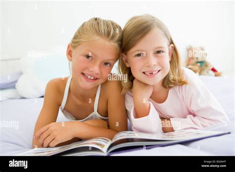 Zwei Junge Mädchen Im Schlafanzug Ein Buch Zu Lesen Stockfotografie Alamy