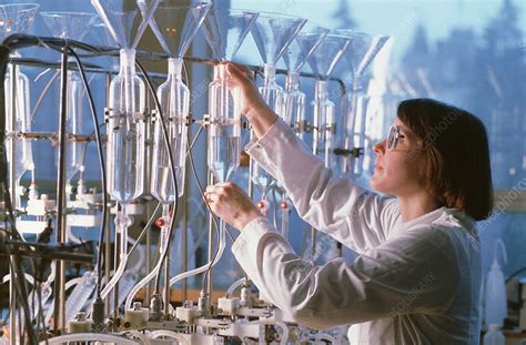 Chemist In Laboratory Working On Row Of Condensers Stock Image T875