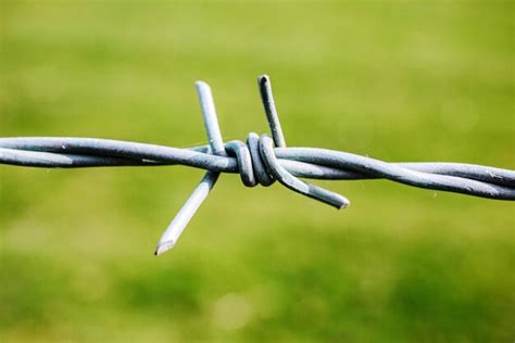 Premium Photo Close Up Of Barbed Wire Fence On Field