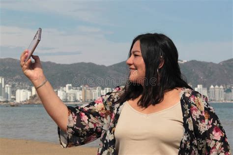40 Year Old Latina Woman Takes Selfies Alone And Calmly While Walking Along The Beach During Her