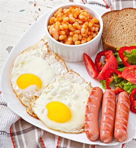 Premium Photo | English breakfast - sausages, eggs, beans and salad