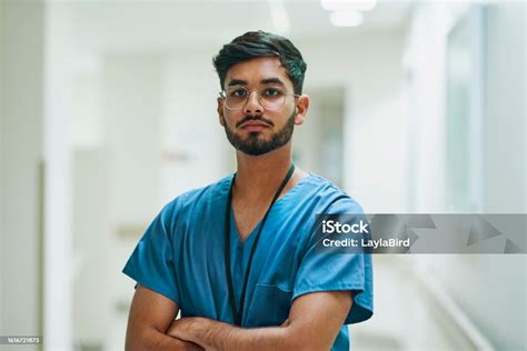 Portrait Of Male Nurse With Beard Crossing Arms Looking At Camera Stock