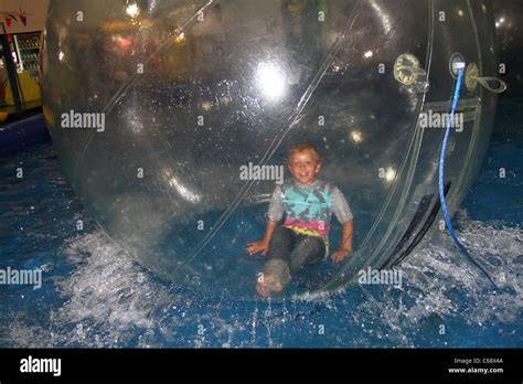 People in clear plastic bubbles running on water in amusement arcade at ...