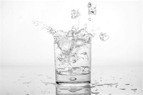 Premium Photo Splashing Of Water With Ice In Glass